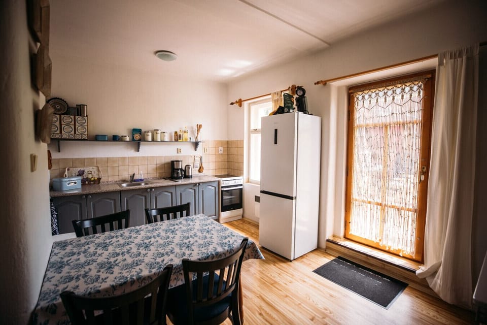 Bright and fully equipped, this charming country kitchen invites you to cook, gather, and enjoy your meals in a warm, homey atmosphere — with direct access to the sunny garden.