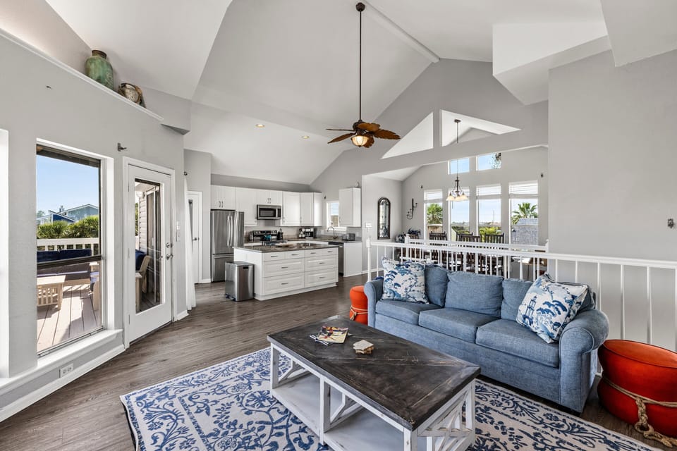Open-concept living and dining area with soaring ceilings, abundant natural light, and seamless access to the gourmet kitchen and outdoor deck.