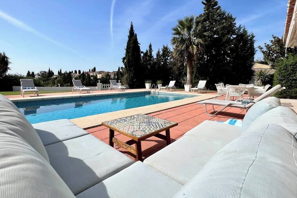 Outdoor seating area overlooking the pool and garden