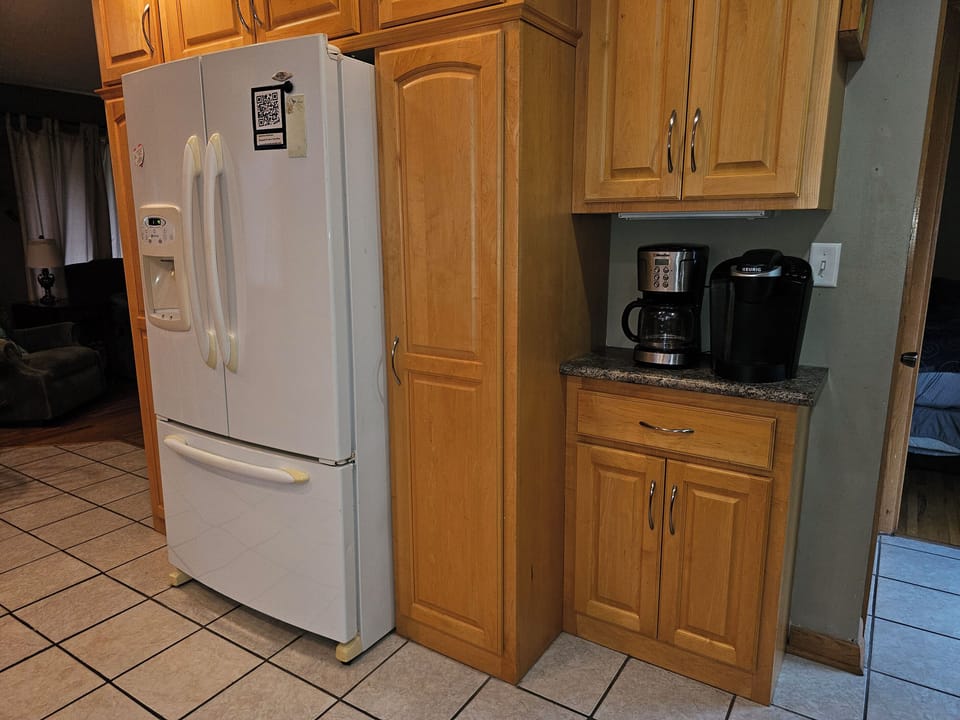 Two different types of coffee makers, full refrigerator