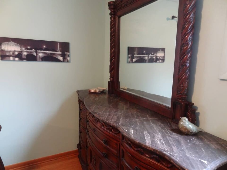 Bedroom with stone top dresser and mirror.