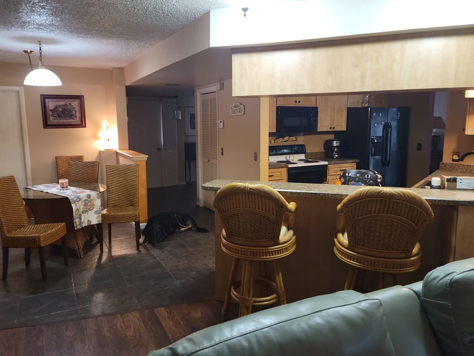 eat in with rattan Kitchen Table and rattan barstools dishes glasses pots pans 
