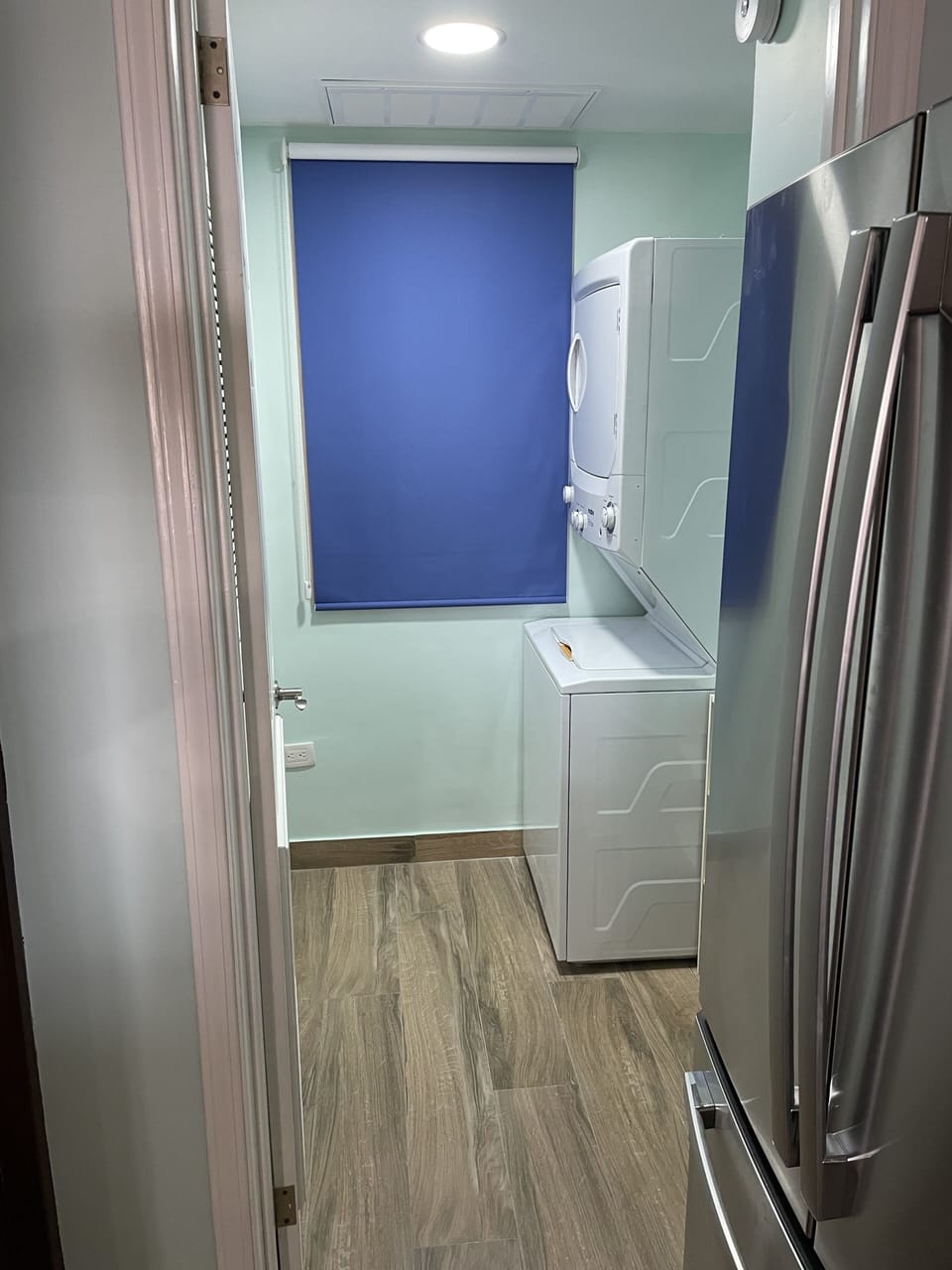 In suite laundry room with stacked washer and dryer