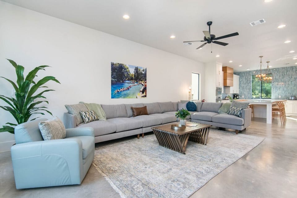 Large living room with oversized couch and Comal River views