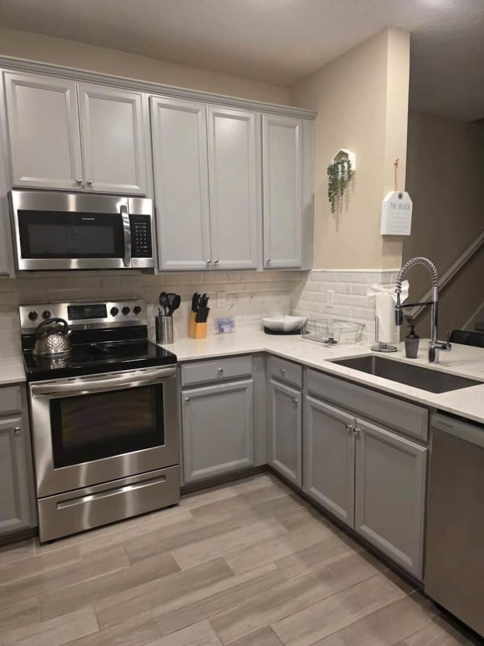 Modern kitchen including dishwasher, cookware, utensils, and basic spices