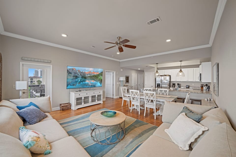 Bright and airy living space featuring plush seating, 86" flat-screen TV, and stunning views of the Gulf right from your couch.