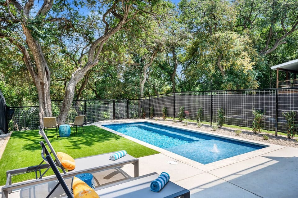Heated pool with outdoor seating and Comal River views