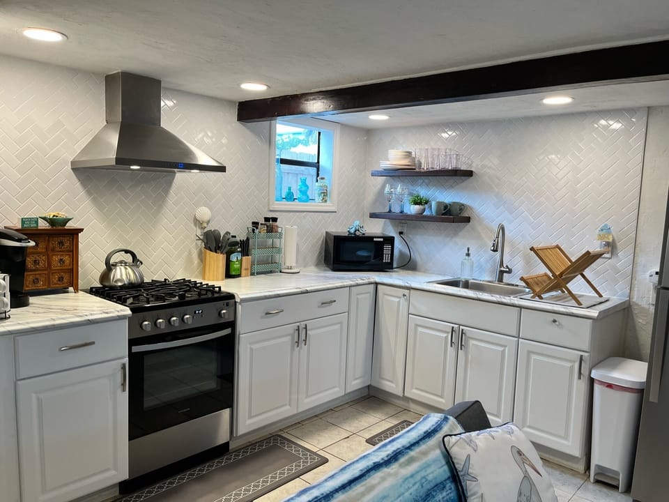 Kitchen includes a fridge, gas range/oven and plenty of cooking supplies.