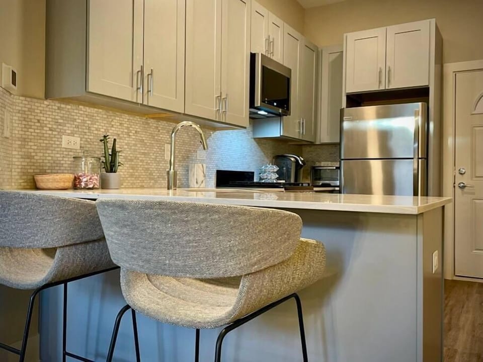 Plush blu-dot Racer stools overlook the fully-stocked kitchen, complete with a Keurig coffee station. 