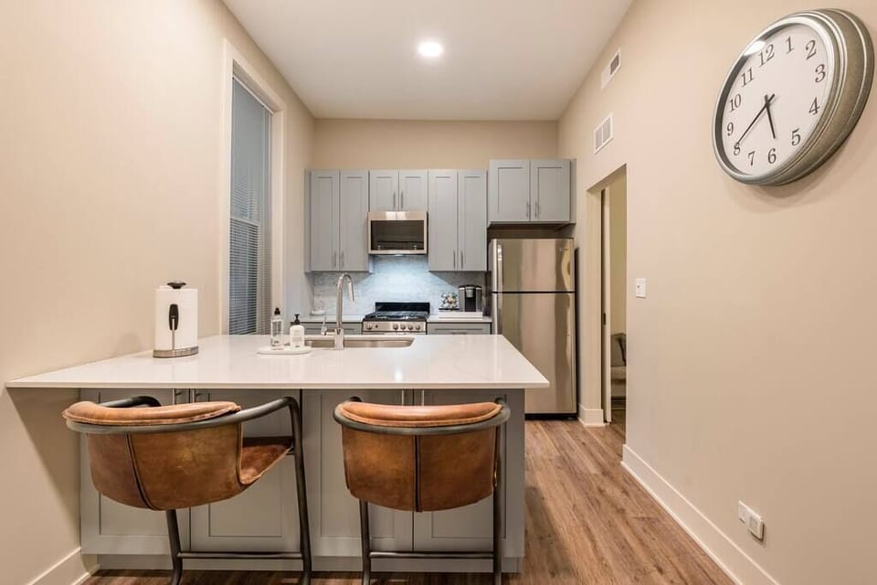 The plush RH counter stools overlook the fully-stocked kitchen, complete with a Keurig coffee station. 