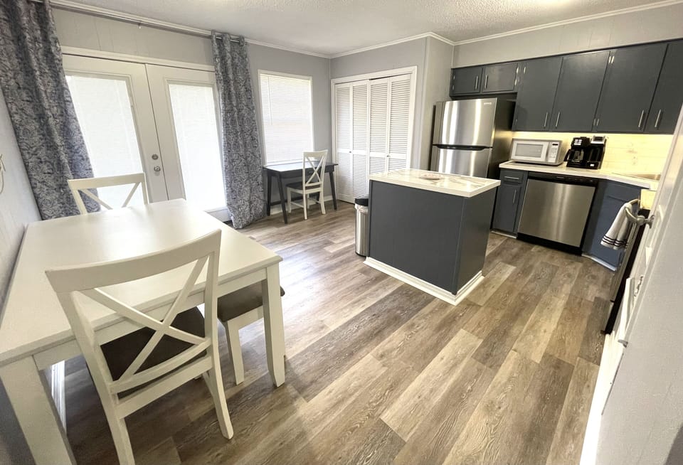 First floor kitchen with work station and washer/dryer. Doors to back patio