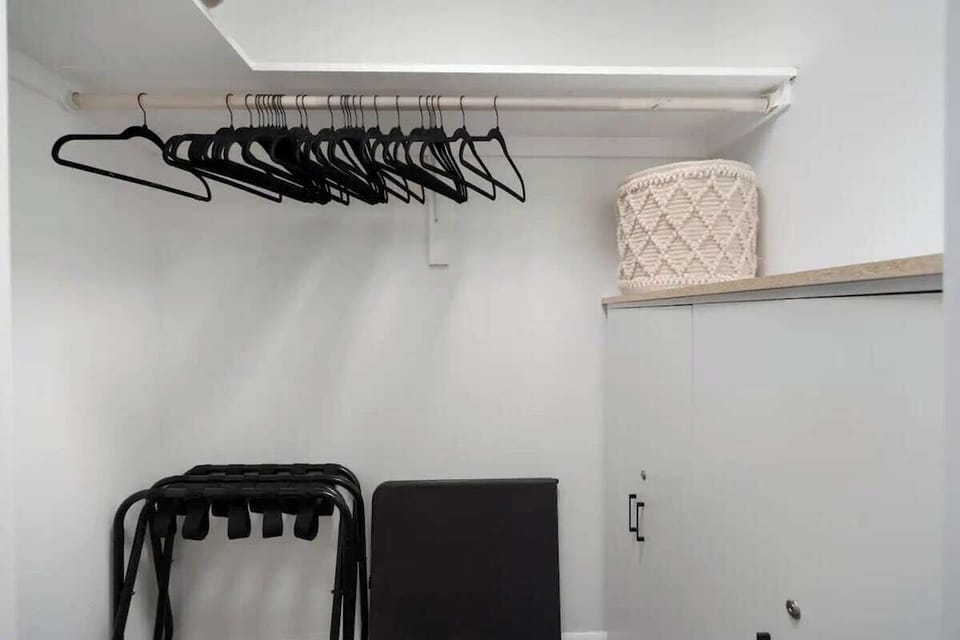 A spacious primary bedroom closet equipped with luggage racks.