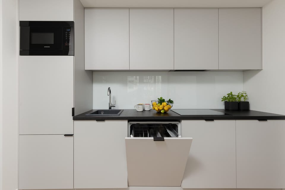 Kitchenette with plenty of kitchen utensils and dishes. 