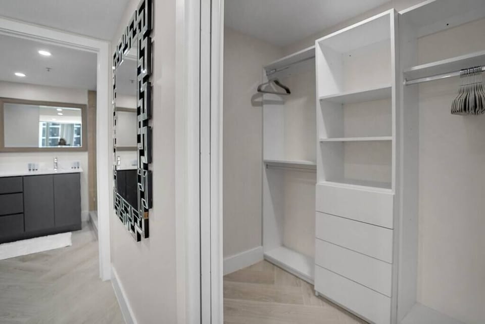 Master bedroom suite walk in closet, view into private bathroom to left
