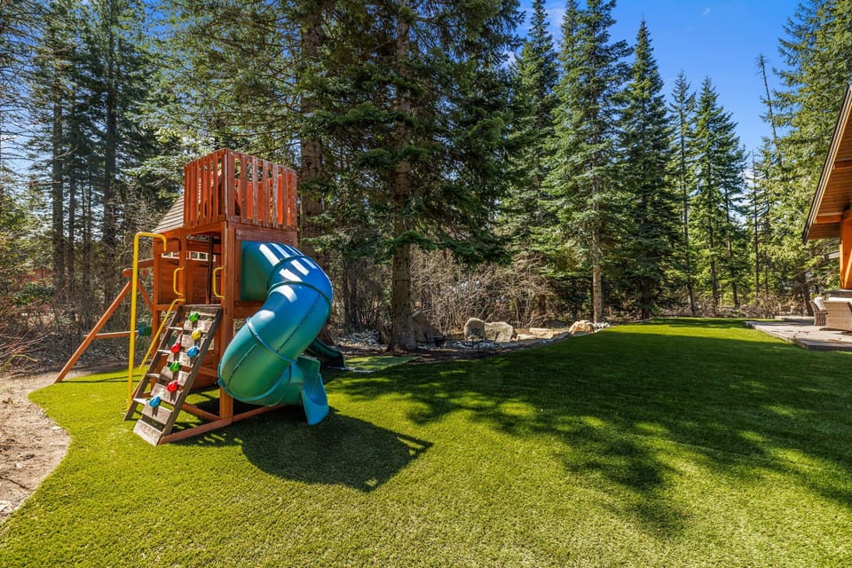 Landscaped Lawn With Play Set And Mountain Backdrop For Family Fun