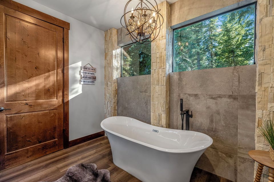 Master En Suite Bathroom with a Free Standing Soaking Tub With Floor-Mount Filler And Wood Accent Wall