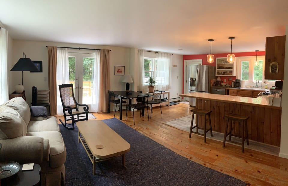 Main room with sitting and dining areas and kitchen with breakfast bar