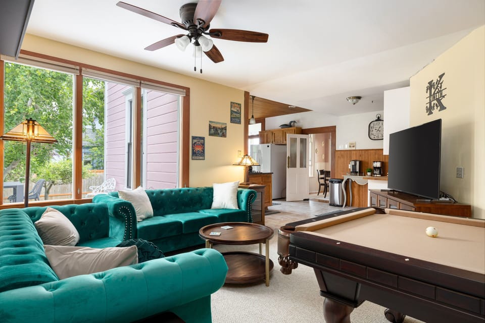 Entertainment room with large 65" TV, Bose sound system and pool table.