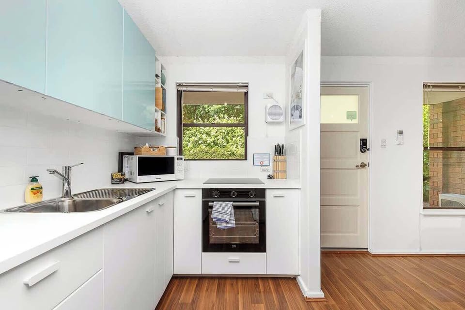Enjoy our well-appointed kitchen, featuring an oven, microwave, stove, and sink for all your cooking needs. Ample kitchen cabinets provide storage, and a convenient window offers natural light.