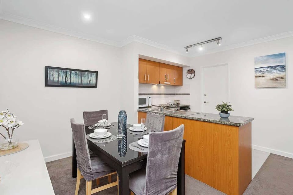 Prepare and enjoy meals with ease in this well-appointed kitchen, complete with ample cabinets and a microwave. A separate dining area comfortably seats four, perfect for shared meals and memorable moments.