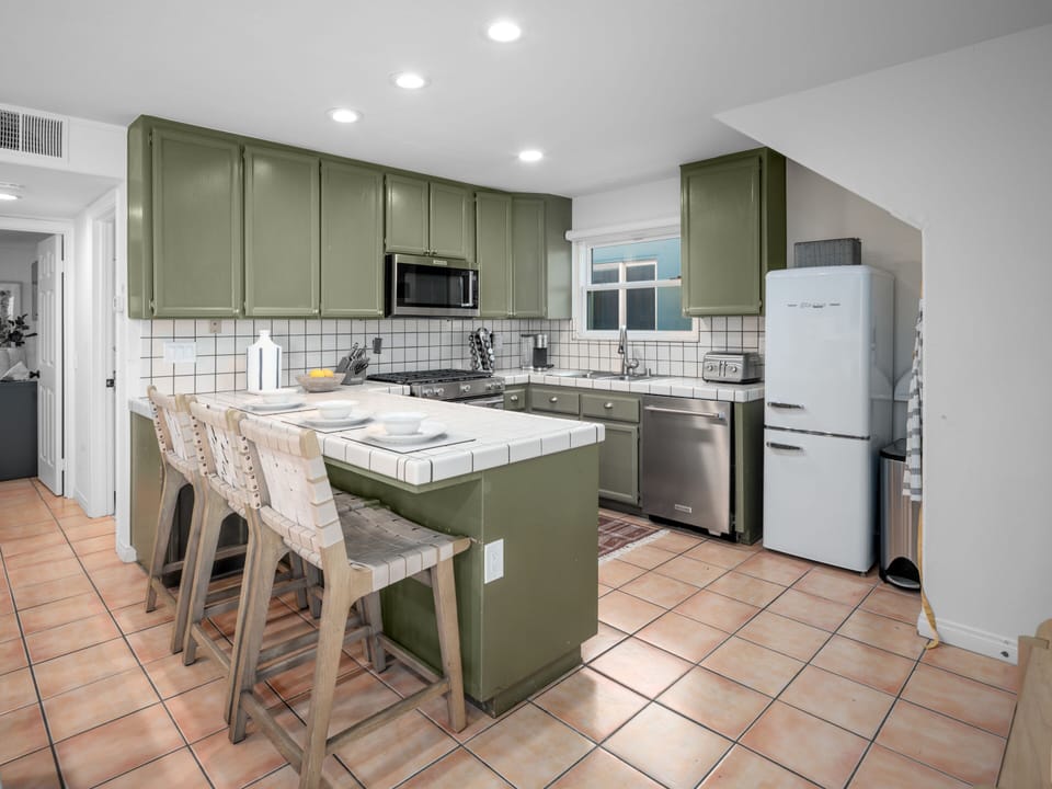 This modern kitchen with a bar provides additional seating, perfect for casual dining and cooking with family.