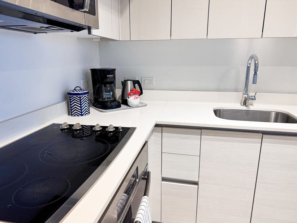 Fully equipped kitchen with stainless steel appliances and a stylish backsplash.