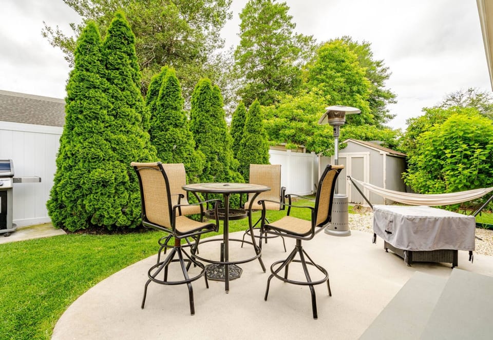 Enclosed backyard has a hammock, an outdoors fireplace, heat and seats to relax.