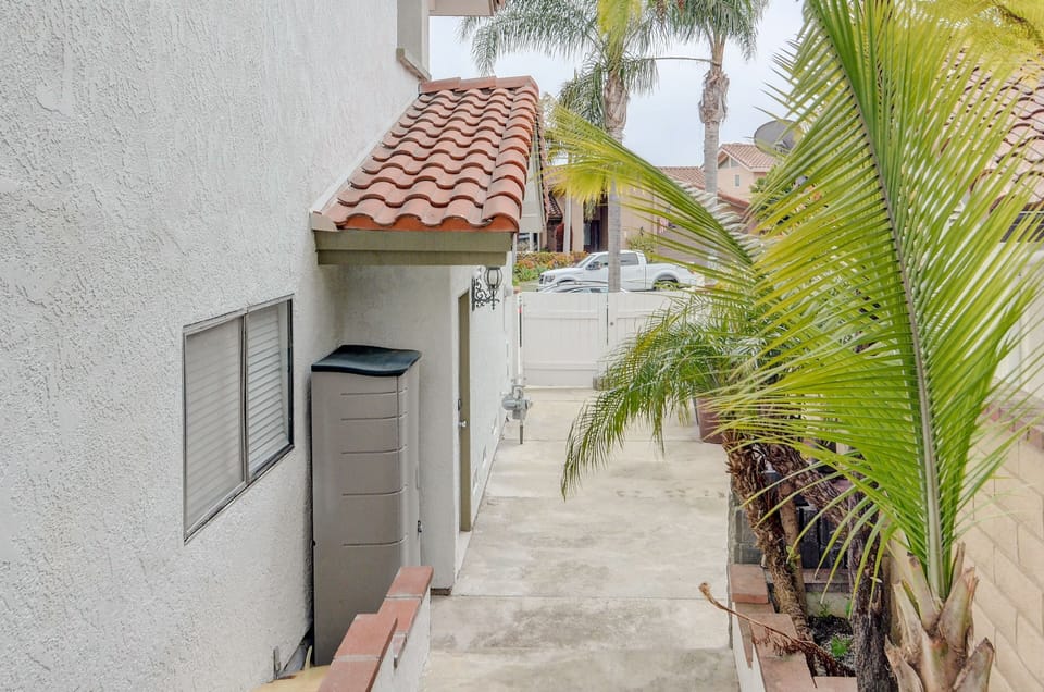 Side yard with steps, leading to backyard and where trash cans are stored.