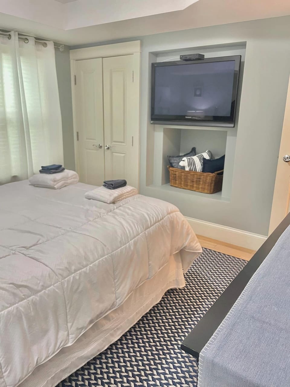 Primary bedroom with double door closet, dresser and television. 