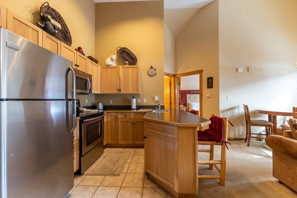 Your fully-equipped kitchen awaits with stainless steel appliances, warm wood cabinetry, and everything you need to create memorable meals together.