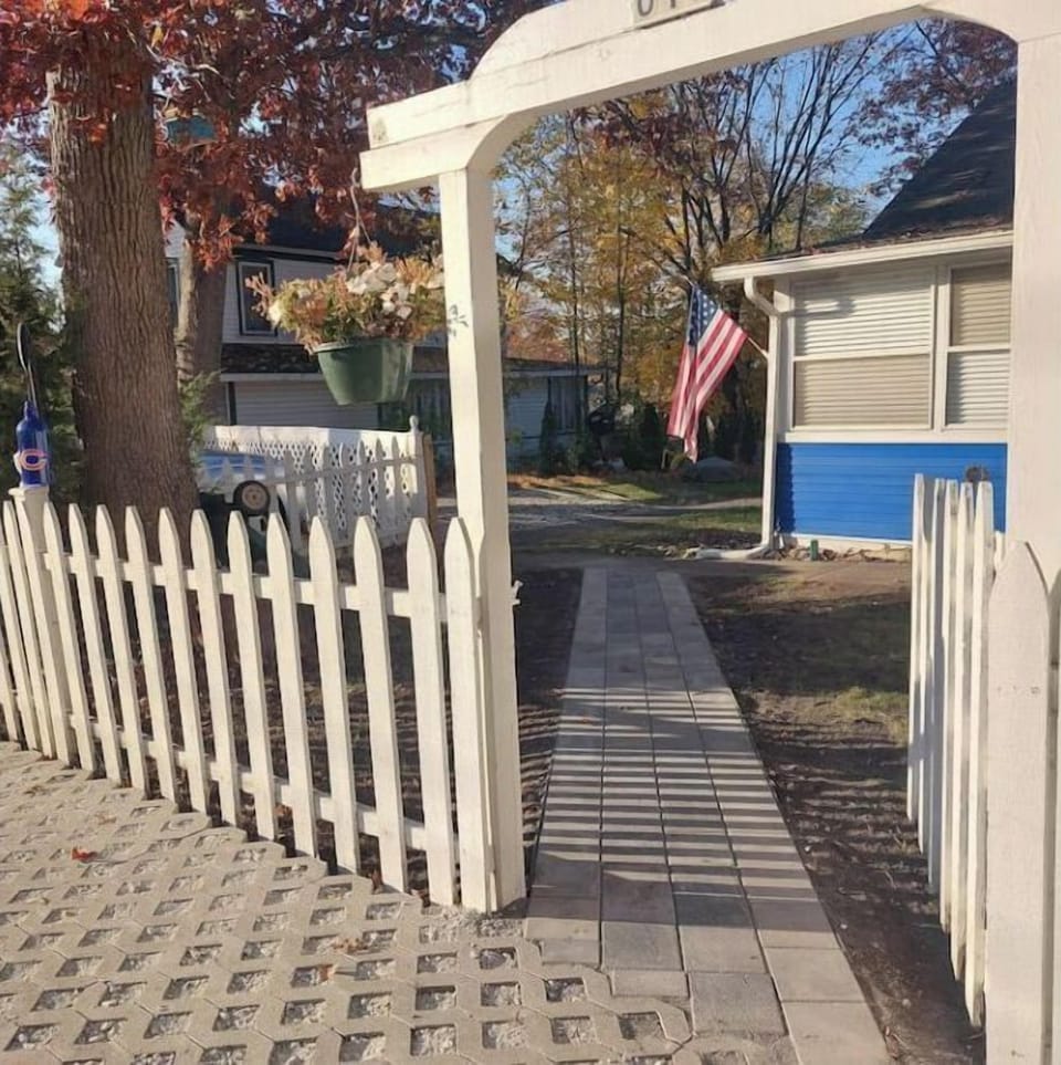 Welcome!  Fully fenced yard.  With netting behind white pickets for tiny dogs.