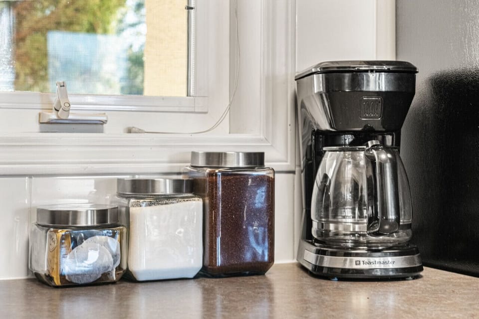 Full kitchen with a drip coffee maker, ground coffee, tea, sugar and condiments (ketchup/mustard/relish.)
