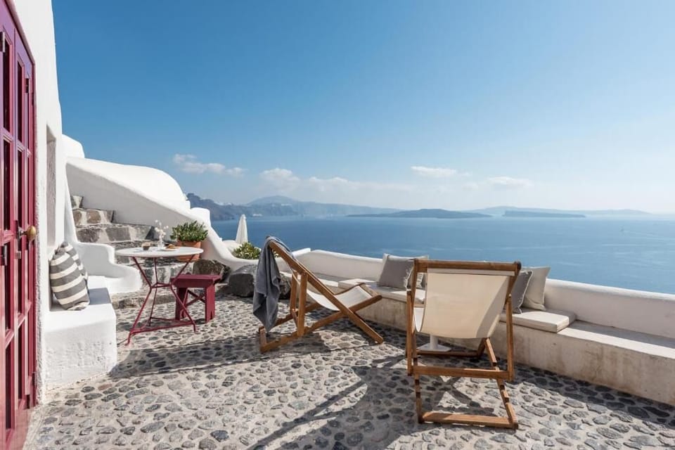 Unwind on the sunlit terrace with endless caldera views.