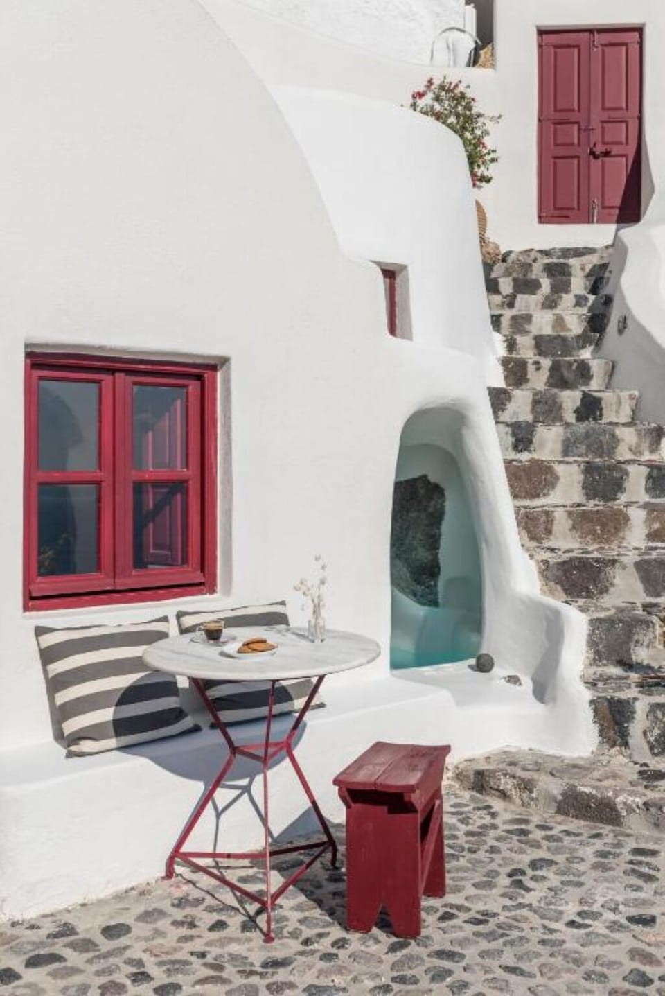 Sip coffee outside on sunlit steps in Cycladic calm.