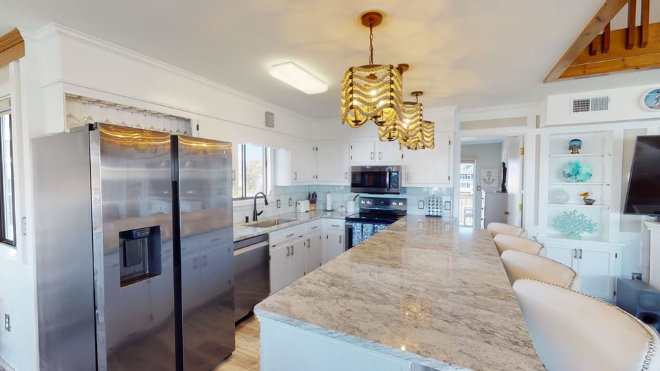 A bright, upscale kitchen featuring sleek finishes and generous space—designed for effortless vacation meals in North Myrtle Beach.