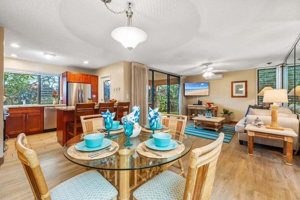A vibrant dining space with a fully set table and open sightlines to the kitchen and lanai, ideal for hosting family dinners.