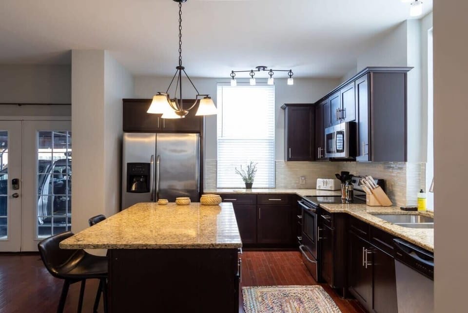 This gorgeous kitchen with dark wood cabinets and granite countertops is calling your name. #TravelInStyle