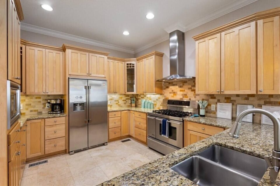 Kitchen showing microwave, fridge, stove and sink (clockwise).