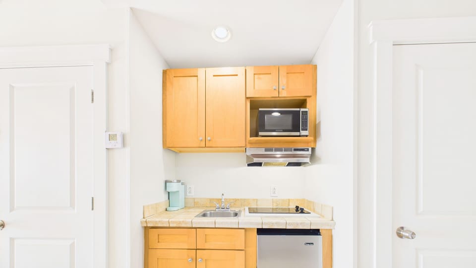 Mess area with stove, mini fridge, and microwave + coffee essentials