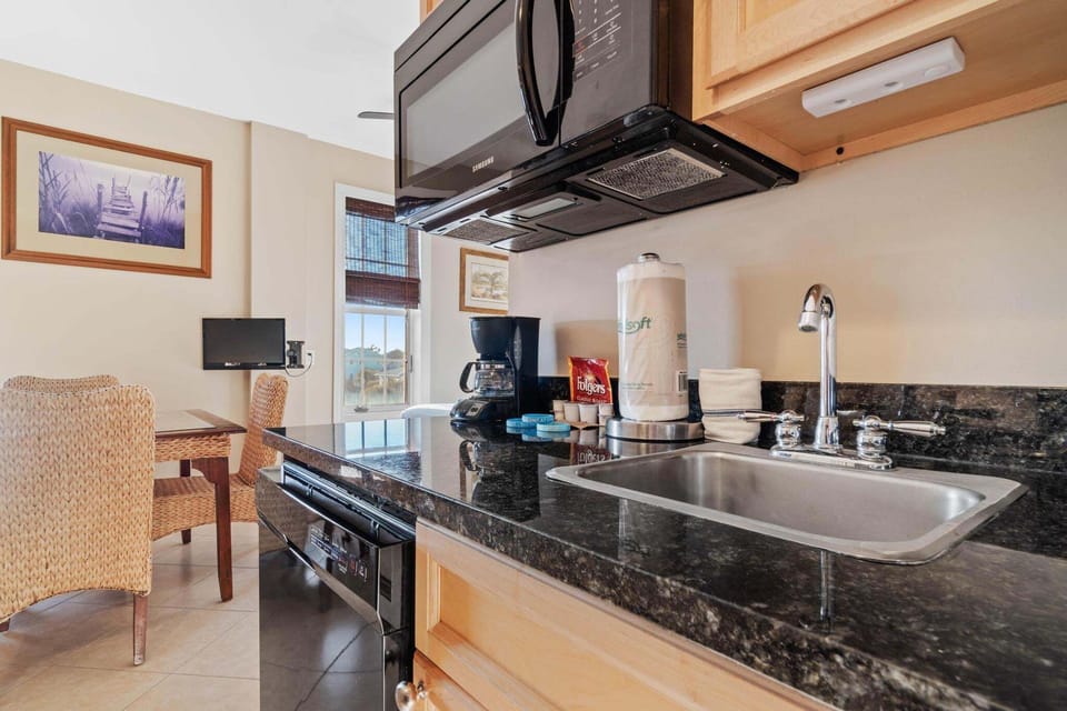 Kitchenette with dishwasher, fridge, and coffee essentials