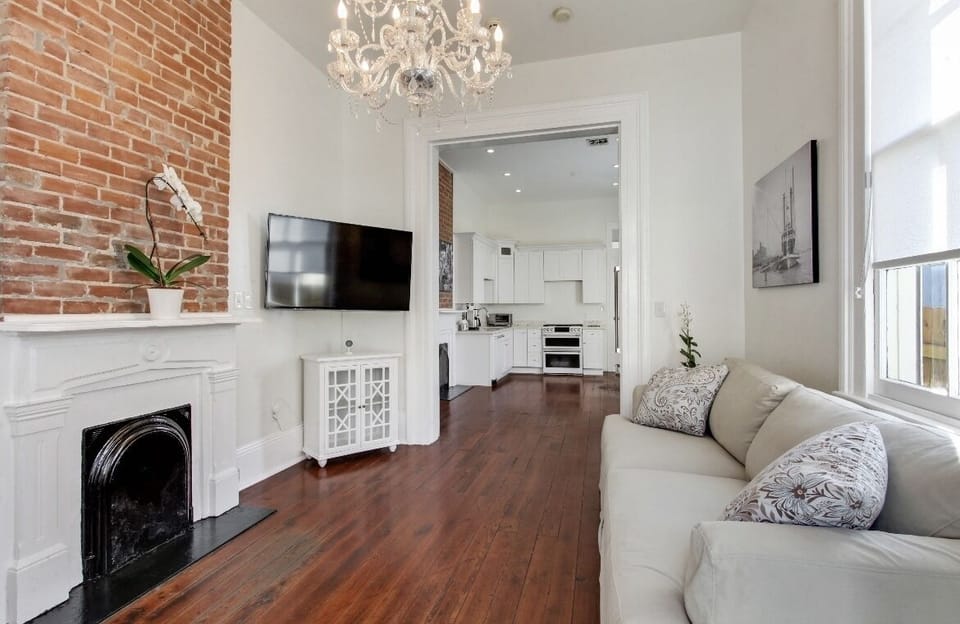 Cozy living room with sofas, vintage brick and a flat screen TV. Bright light.