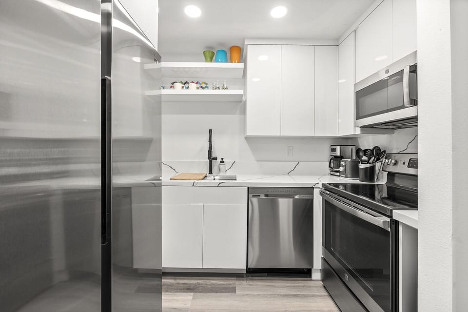 - Fully equipped Palm Springs kitchen with stainless steel appliances and quartz countertops   - Open shelving and sleek cabinetry add modern charm and convenience   - Ideal space to cook favorite meals during your Palm Springs getaway