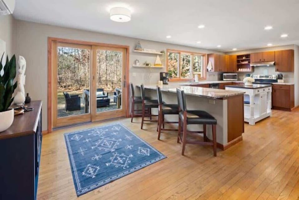 Comfortable barstools at the peninsula, situated next to large slider leading to the back patio