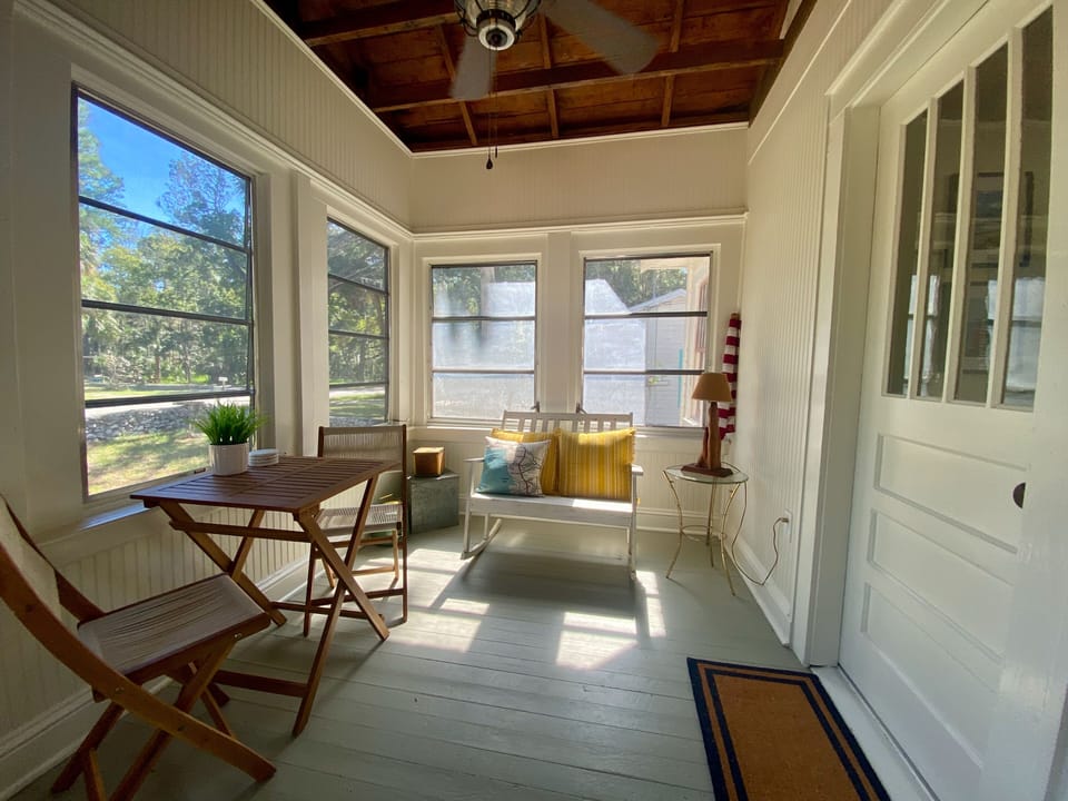 Sunny Florida room with dinette and rocker, sip and relax in natural light.