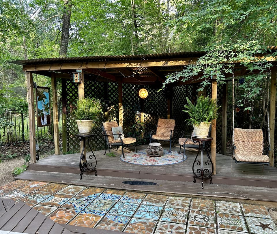 Comfy covered seating area off private back deck, with swing chair. 
