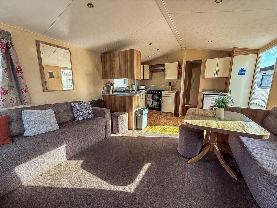 Relax in the cosy living room in a caravan at Park Holidays Broadland Sands, the perfect base for exploring Great Yarmouth, Norfolk, and its many attractions like the Hippodrome Great Yarmouth and Pleasure Beach Great Yarmouth.