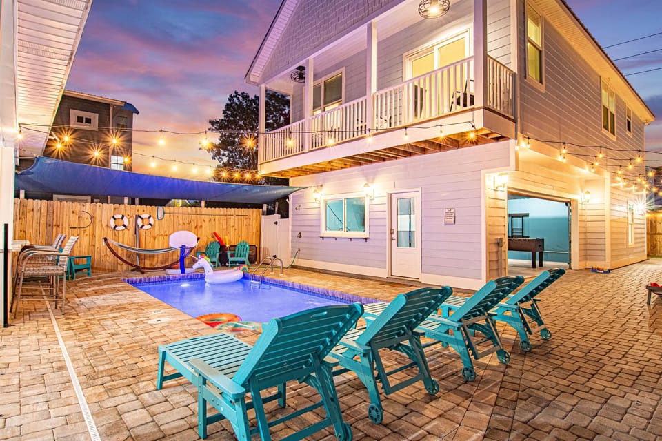 [Backyard] Outdoor courtyard between main hours and carriage house complete with seating for 16, out door games with putting green, and corn hole to name a few. Overlooking the amazing pool with removable CHILD SAFTEY FENCE and outdoor TV