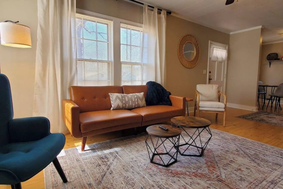 Cozy and stylish living area with comfy seating, smart TV, and modern decor. Enjoy a spacious layout with dining space, natural light, and a fully equipped kitchen—perfect for relaxing or working remotely.