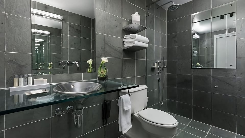 Refresh under the rainfall shower in sleek, modern stone surrounds.