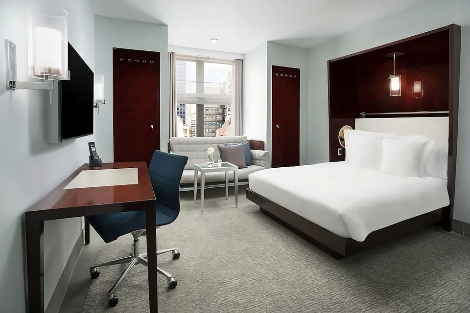 Relax in a bright, modern room with desk and seating.